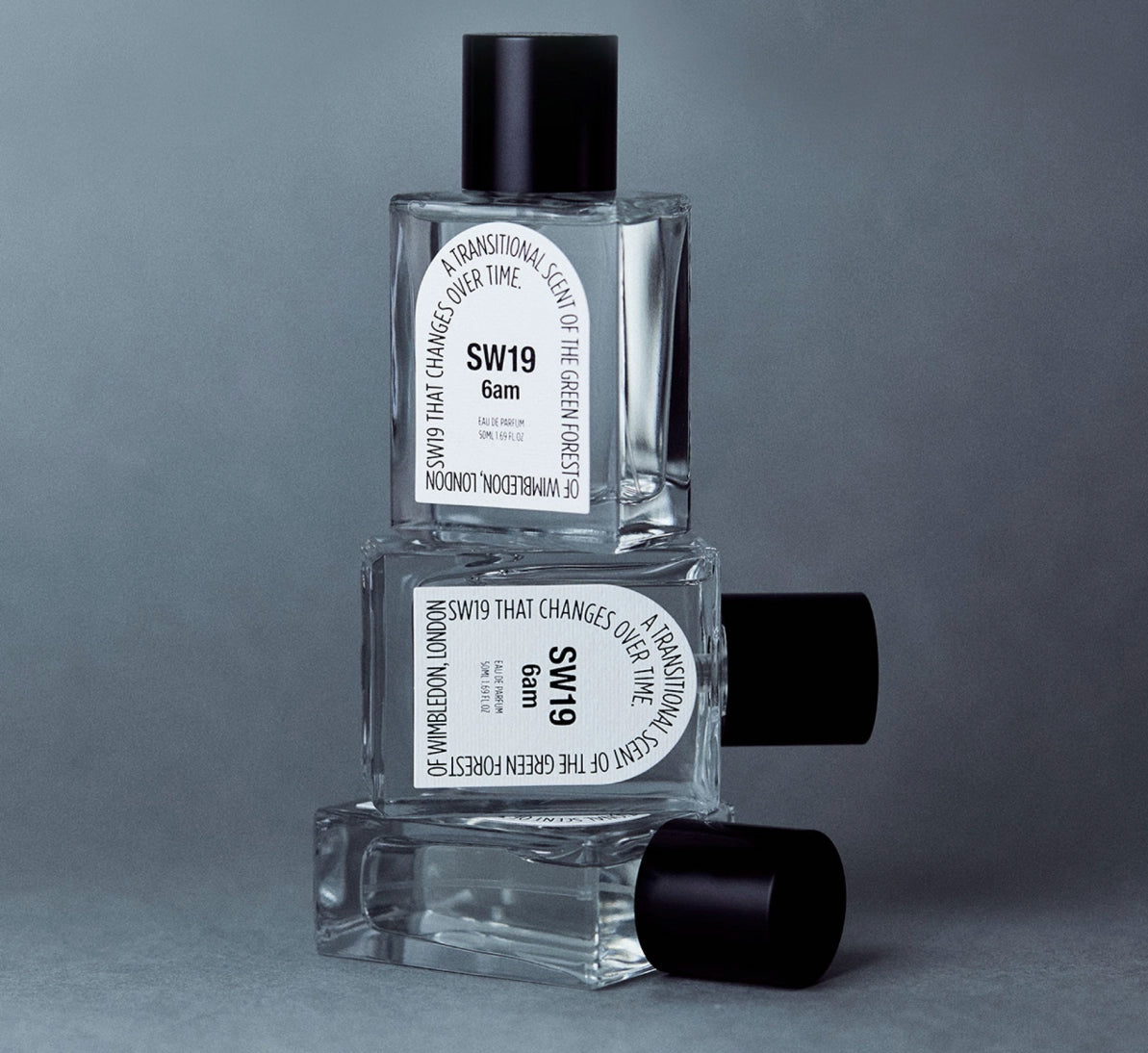 Stacked bottles of SW19 Signature Masterpiece perfumes showcasing sleek minimalist packaging and modern fragrance design.